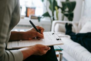 Psychologist in Coquitlam writing notes during a therapy session with a client