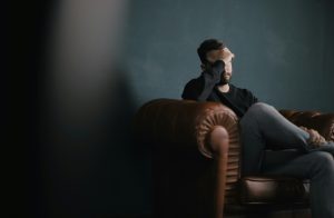 Man sitting on couch looking stressed during therapy session in Coquitlam