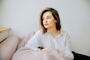 Woman sitting thoughtfully, reflecting on whether she may need therapy in Coquitlam