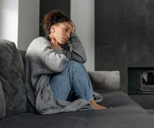 A woman is feeling stressed and irritable without a clear reason why representing possible signs of unresolved trauma.